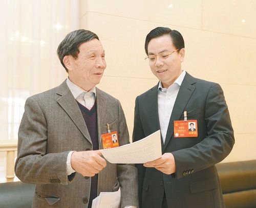 黃伯云代表（左）與劉國忠代表商討完善《關(guān)于建立戰略性新興產(chǎn)業(yè)國家創(chuàng  )新平臺》的建議。 本報記者 張目 攝